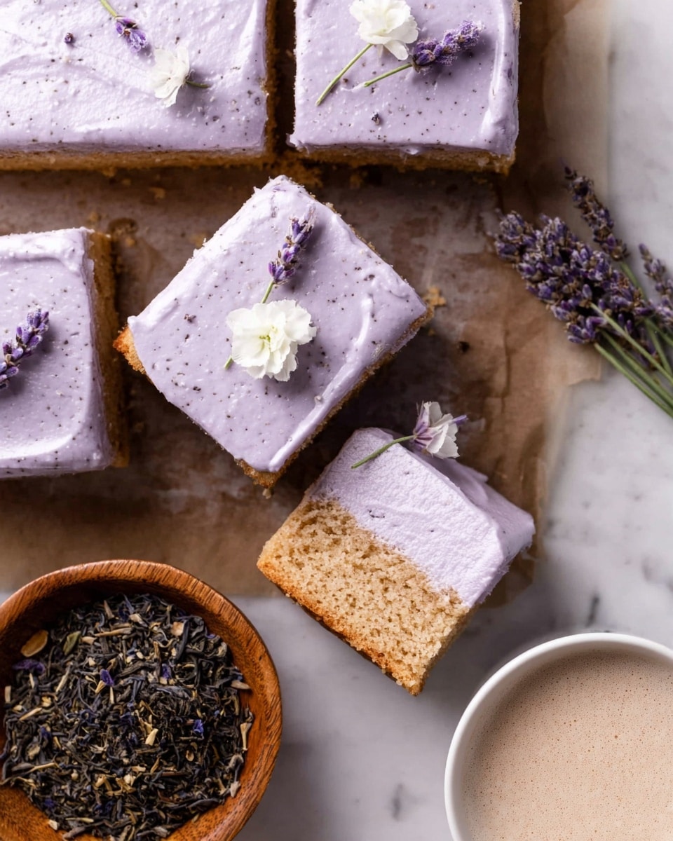 The image shows several square cake pieces with one piece slightly lifted to reveal two layers: a light brown sponge cake base topped with a thick, smooth layer of light purple frosting that has tiny dark specks spread evenly. One cake piece is decorated with small lavender flowers and a white flower on top. To the side, there is a round wooden bowl filled with dried lavender and tea leaves, and a white cup filled with a foamy light-colored drink. The setup is on a white marbled surface, creating a clean and fresh look. Photo taken with an iphone --ar 4:5 --v 7