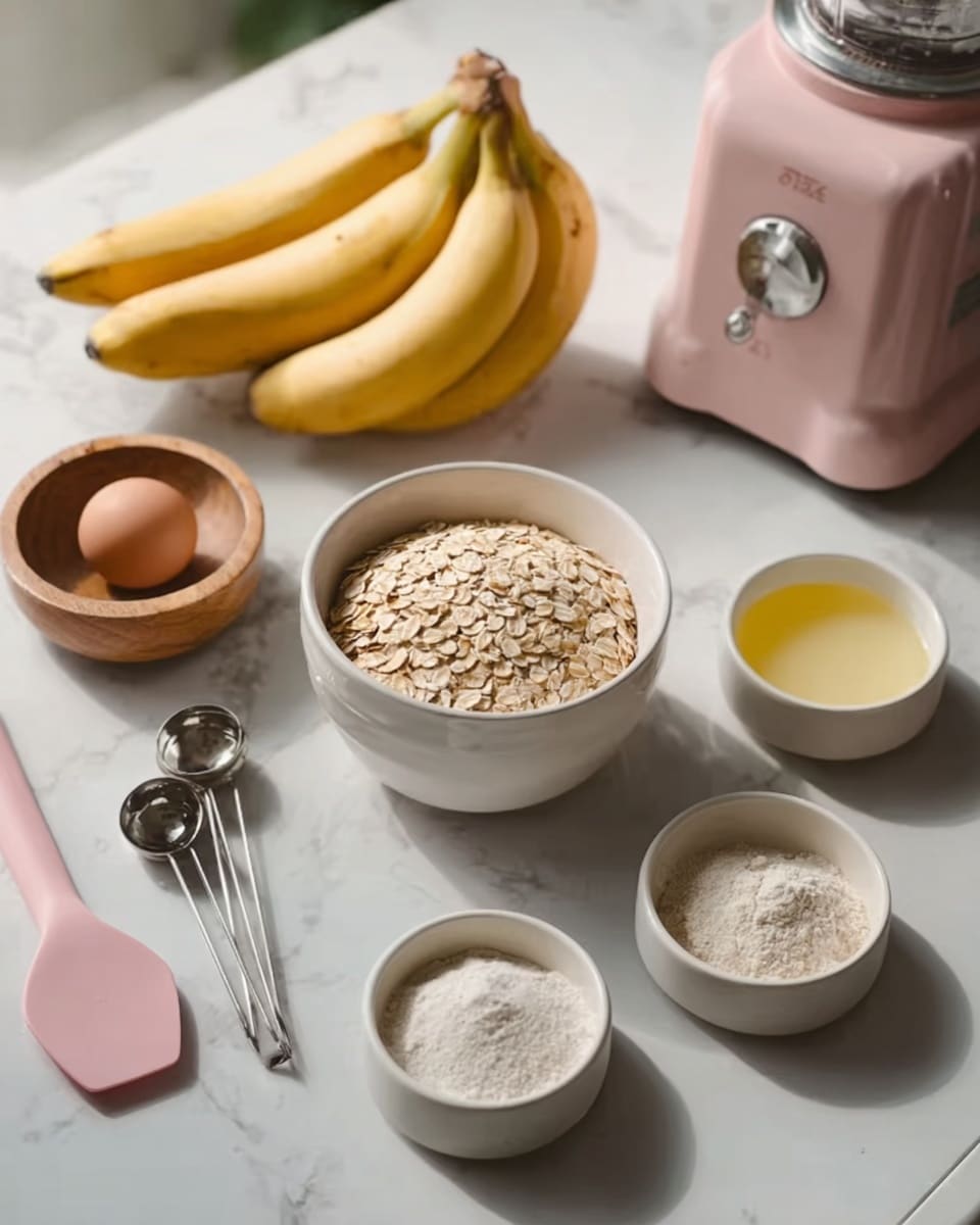 The image shows a white marbled surface with various baking ingredients neatly arranged. In the back, there is a wooden bowl filled with oats, next to two yellow bananas. In front of these, a white bowl holds a single brown egg, and next to it is a small white bowl with a light yellow liquid. Around these main items are three small white bowls containing flour, salt, and baking powder. A pair of metal measuring spoons sits near the left side of the frame. On the right side, a pink silicone spatula leans on the surface, and a pink blender with a silver knob is partly visible in the background. The light is soft and natural, creating a warm and clean baking setup. Photo taken with an iphone --ar 4:5 --v 7