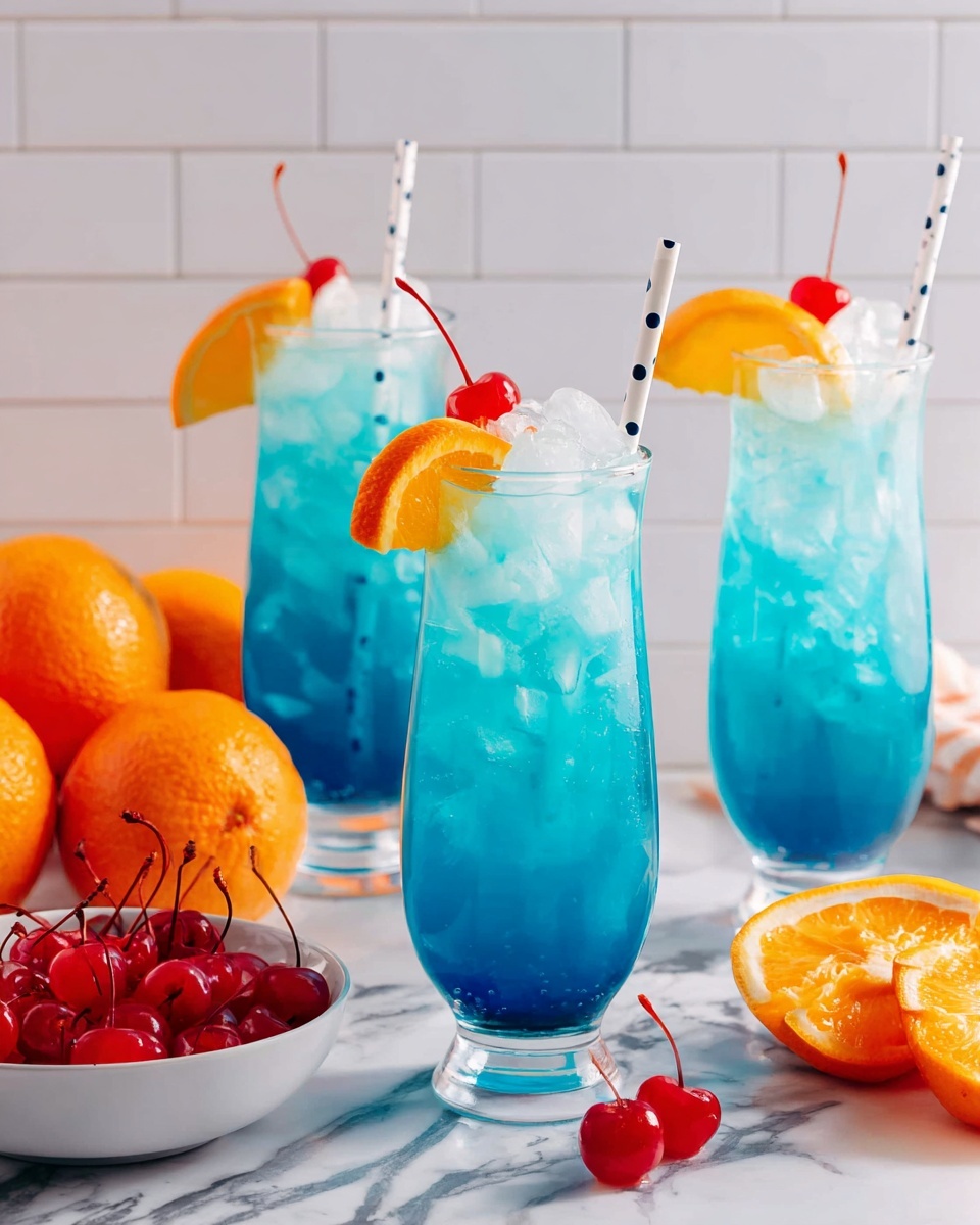 Three tall glasses hold bright blue drinks with large ice cubes inside. Each glass has a white straw with black dots placed near the top center. The drinks are topped with an orange slice and a red cherry on the rim. The glasses are on a white marbled surface. To the left, there is a white bowl filled with bright red cherries, and beside it, a pile of whole oranges sits directly on the marble. The background is made of white tiles. The photo taken with an iphone --ar 4:5 --v 7