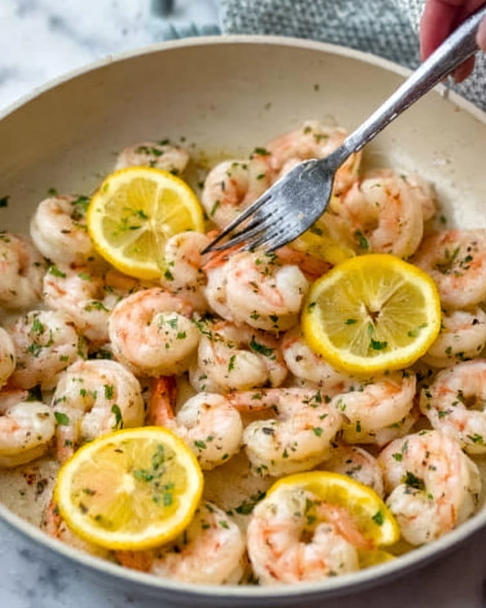 The image shows a white pan filled with cooked shrimp that are light pink with some brown spots, scattered evenly. There are several thin slices of bright yellow lemon mixed in among the shrimp. The shrimp are sprinkled with small green herb pieces, adding color contrast. A woman's hand is holding a fork above the pan, and the background is a white marbled texture. photo taken with an iphone --ar 4:5 --v 7
