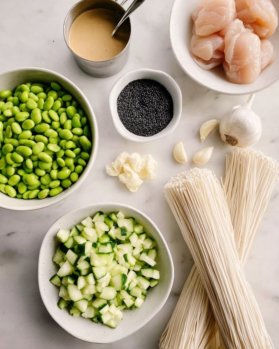 The image shows several white bowls and small dishes arranged on a white marbled surface. In the top left, one white bowl is filled with bright green edamame beans. Near the center, a small white dish holds black sesame seeds. To the right, a white bowl contains two raw, light pink pieces of chicken. In the bottom center, a white bowl is filled with chopped cucumbers, showing green skin and pale green inside. Two bundles of uncooked white noodles lie near the bowls. A small metal cup with creamy tan sauce and several peeled garlic cloves are placed around the bowls. Photo taken with an iphone --ar 4:5 --v 7